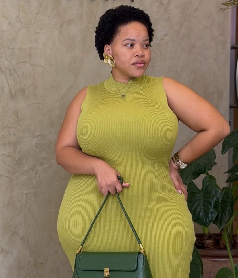Tirelo Kale wearing a green gown and holding a bag